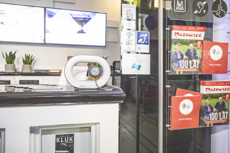 Przenośna pętla indukcyjna ustawiona na ladzie przy wejściu do Mazowieckiego Instytutu Kultury.